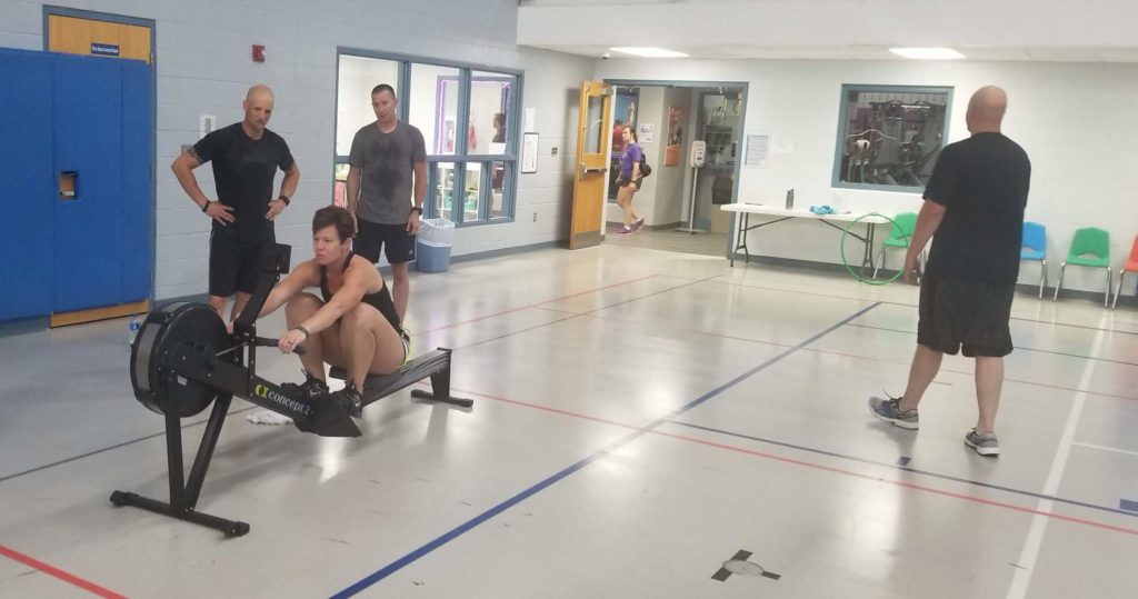 members of a fitness community doing rowing intervals