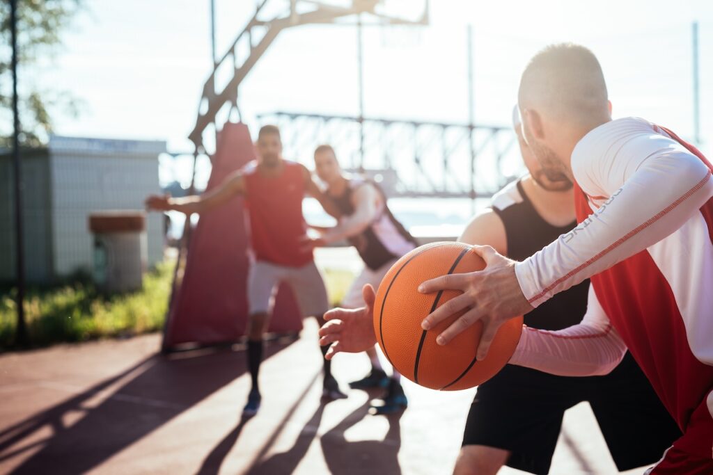 Players engaged in a recreational basketball game, showcasing the benefits of recreational sports.