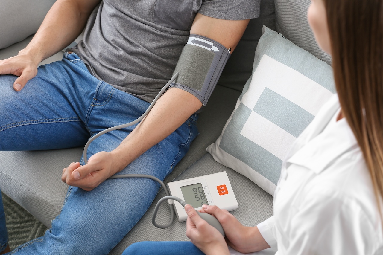 A healthcare professional measures a patient's blood pressure with a digital monitor, a scenario that might be influenced by coffee consumption and its impact on high blood pressure